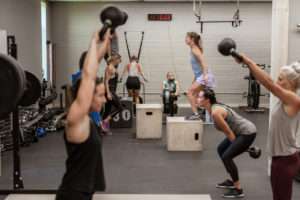 group of people doing various exercises in a gym