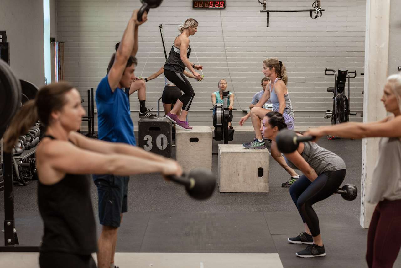 group of people doing various exercises in a gym
