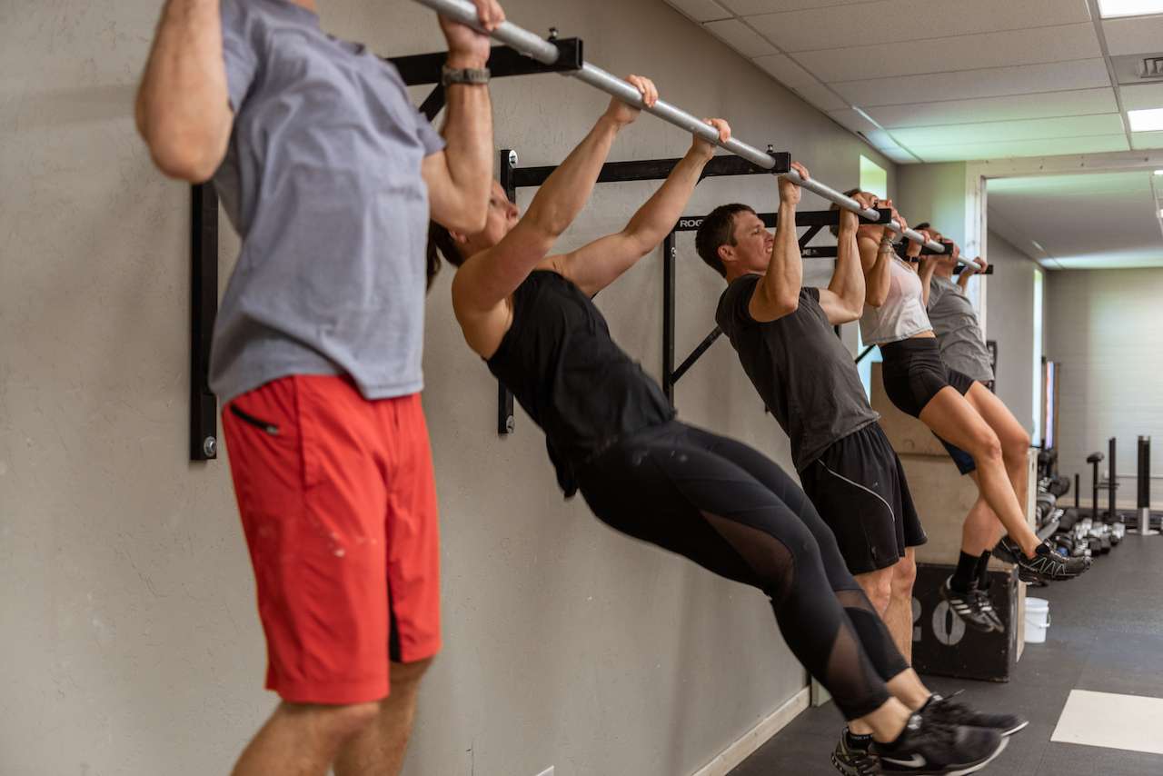 people in a fitness class doing pullups